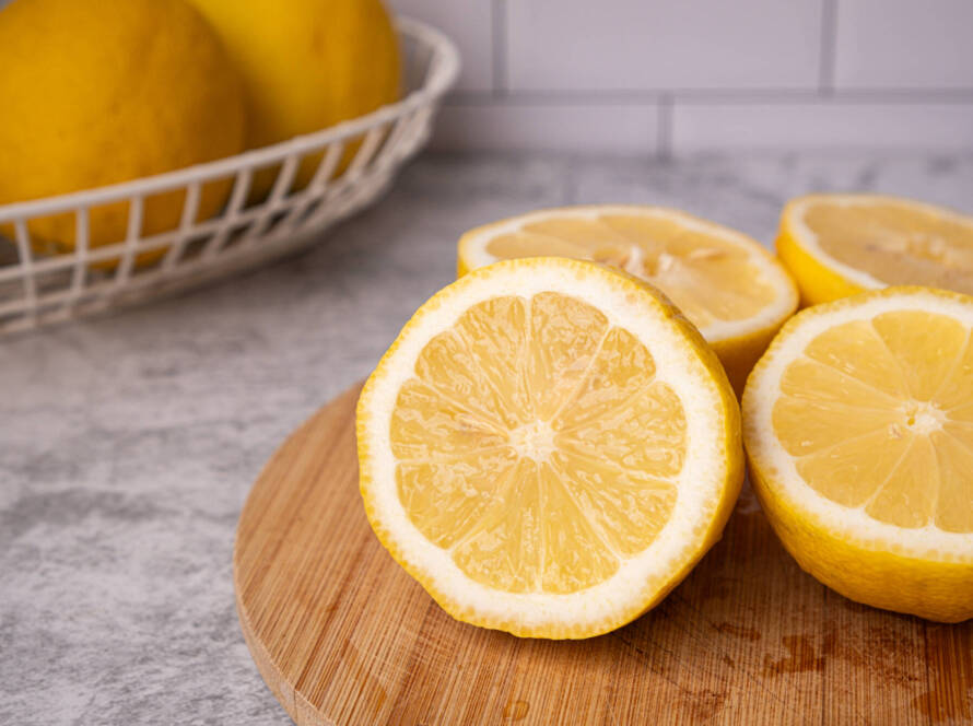 close up lemon cut on the wooden table for making healthy lemonade drink or vitamin C .