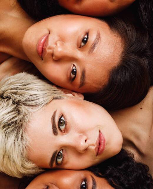 Beautiful young women lying on top of each other, looking at camera